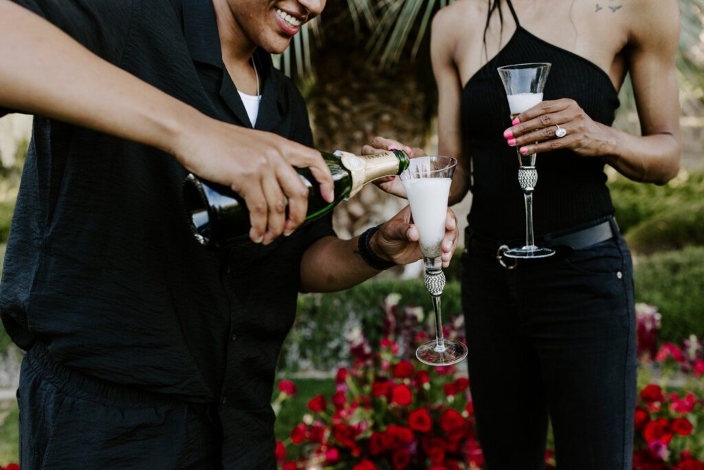 Couple pouring champagne to celebrate being engaged. 