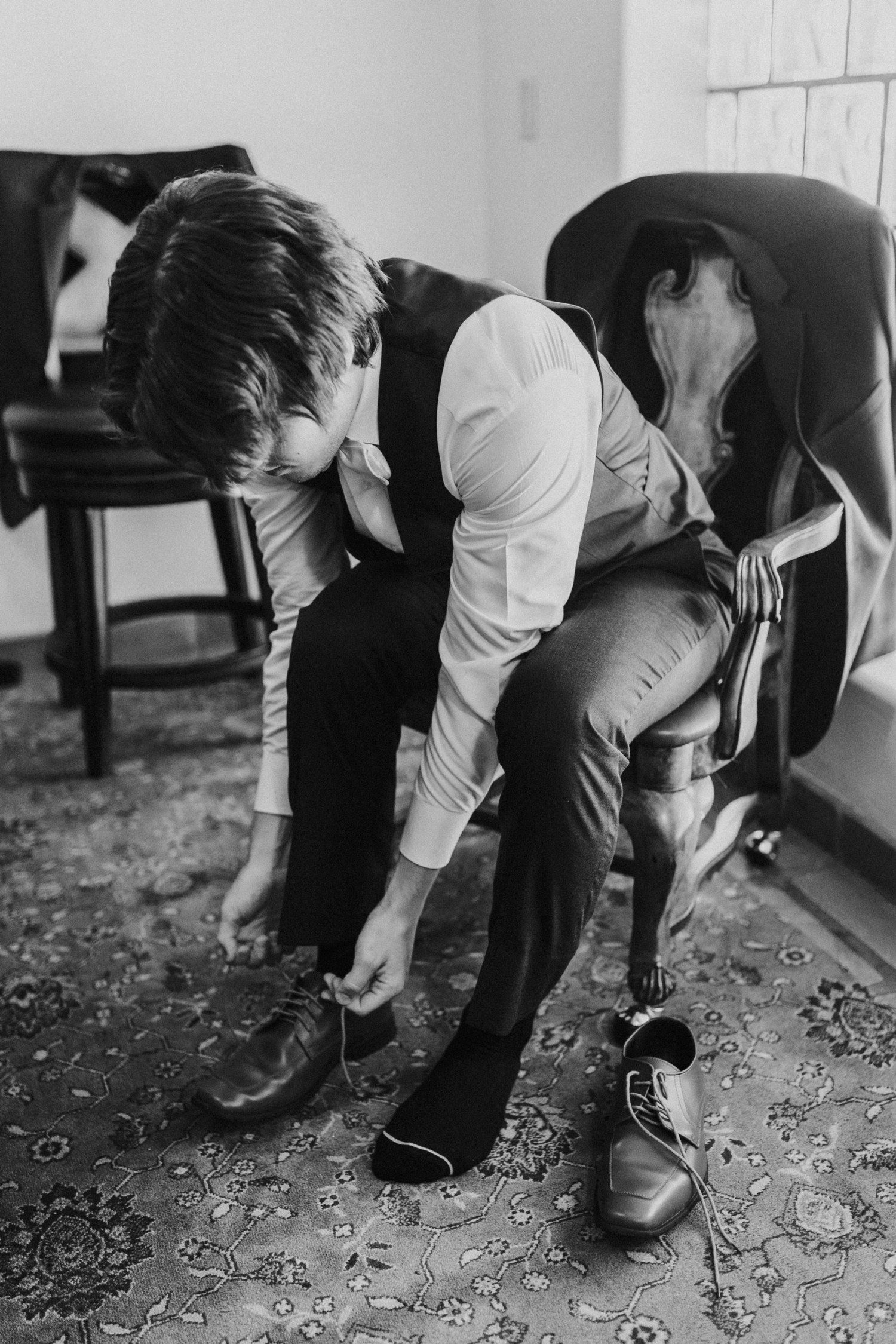 Groom putting on wedding shoes