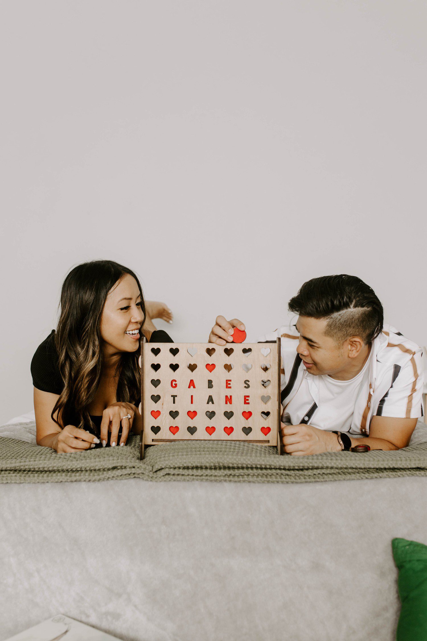 Couple playing connect four board game for engagement photos