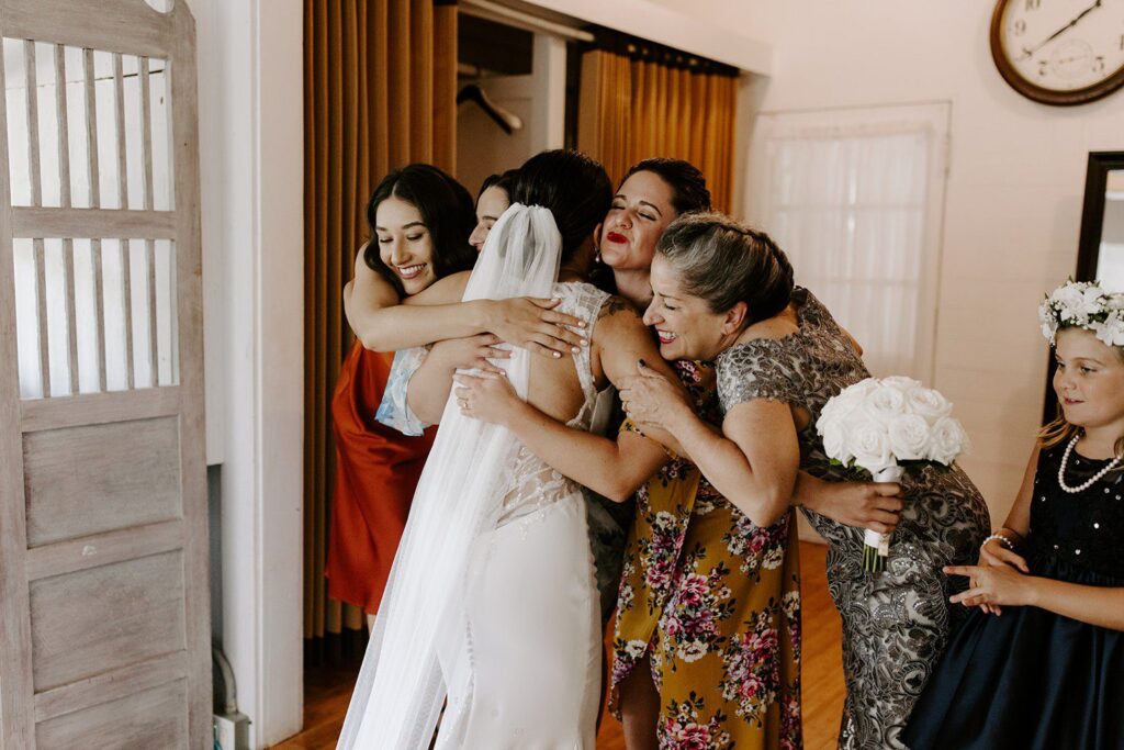 Bride hugging family before wedding in oahu