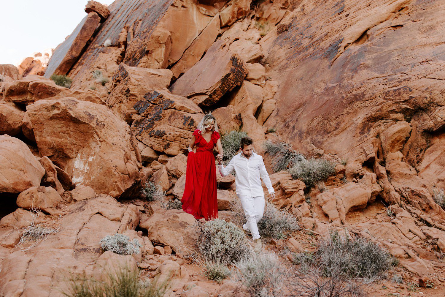 Couple walking together during engagement session at Valley of Fire. 