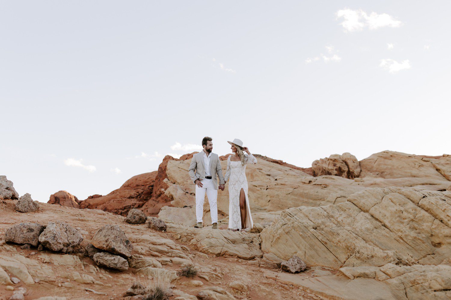 Girl wearing hat and white dress for engagement session at Valley of Fire. 