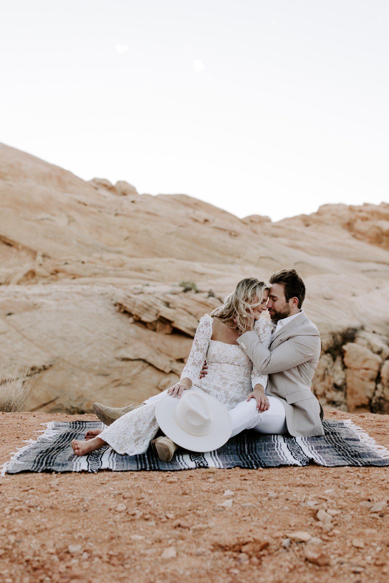 Couple sitting on blanket together for engagement photos at Valley of Fire. 