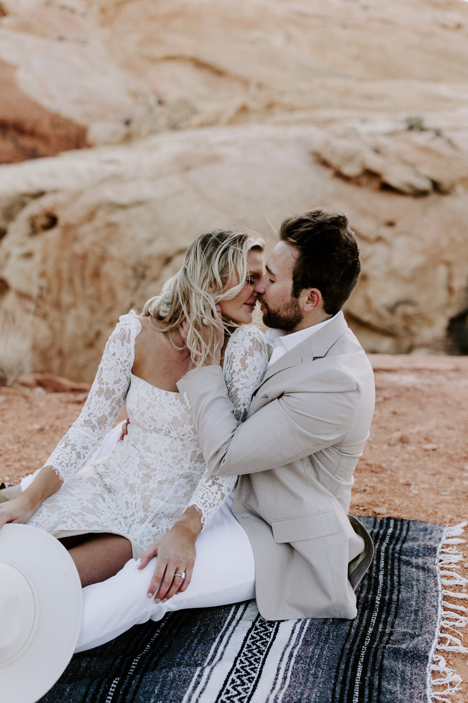 Couple sitting together at Valley of Fire for engagement session. 