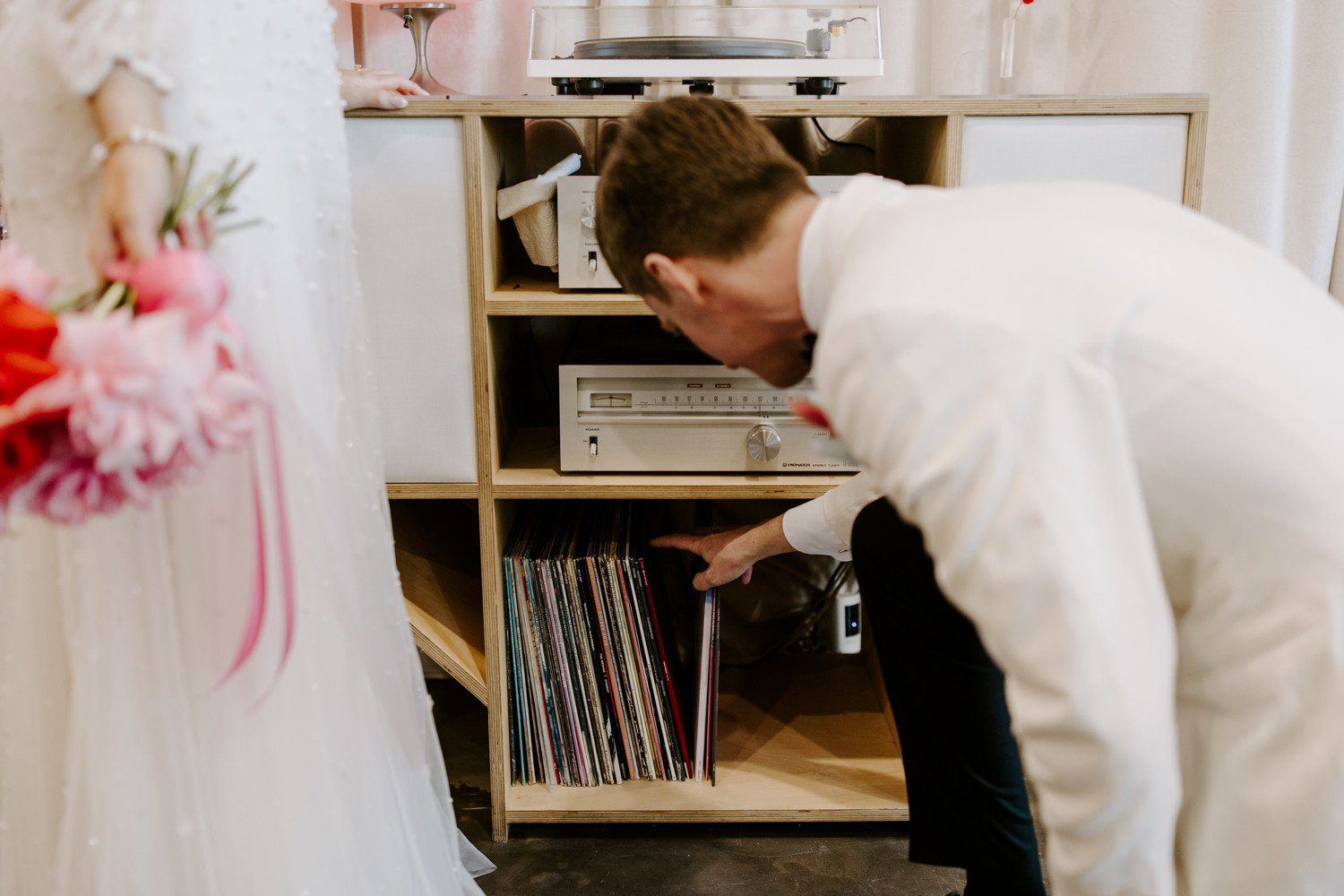 Groom selecting record for record player 