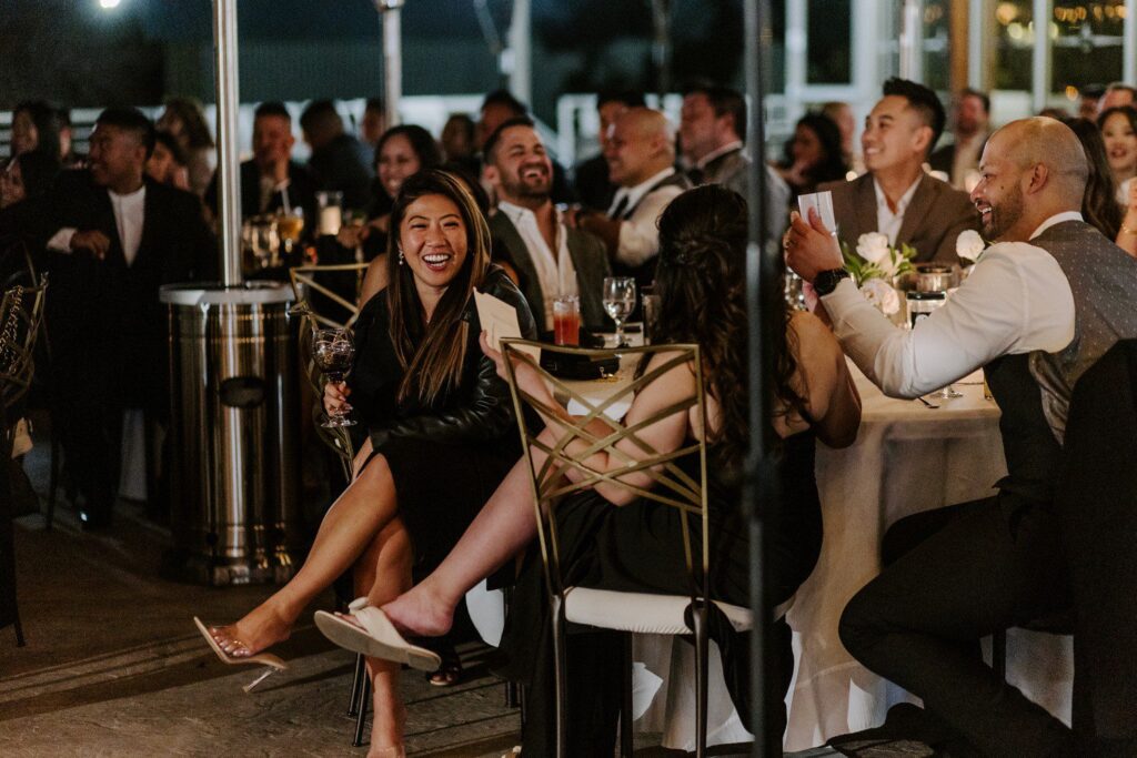 Guests laughing during wedding reception. 