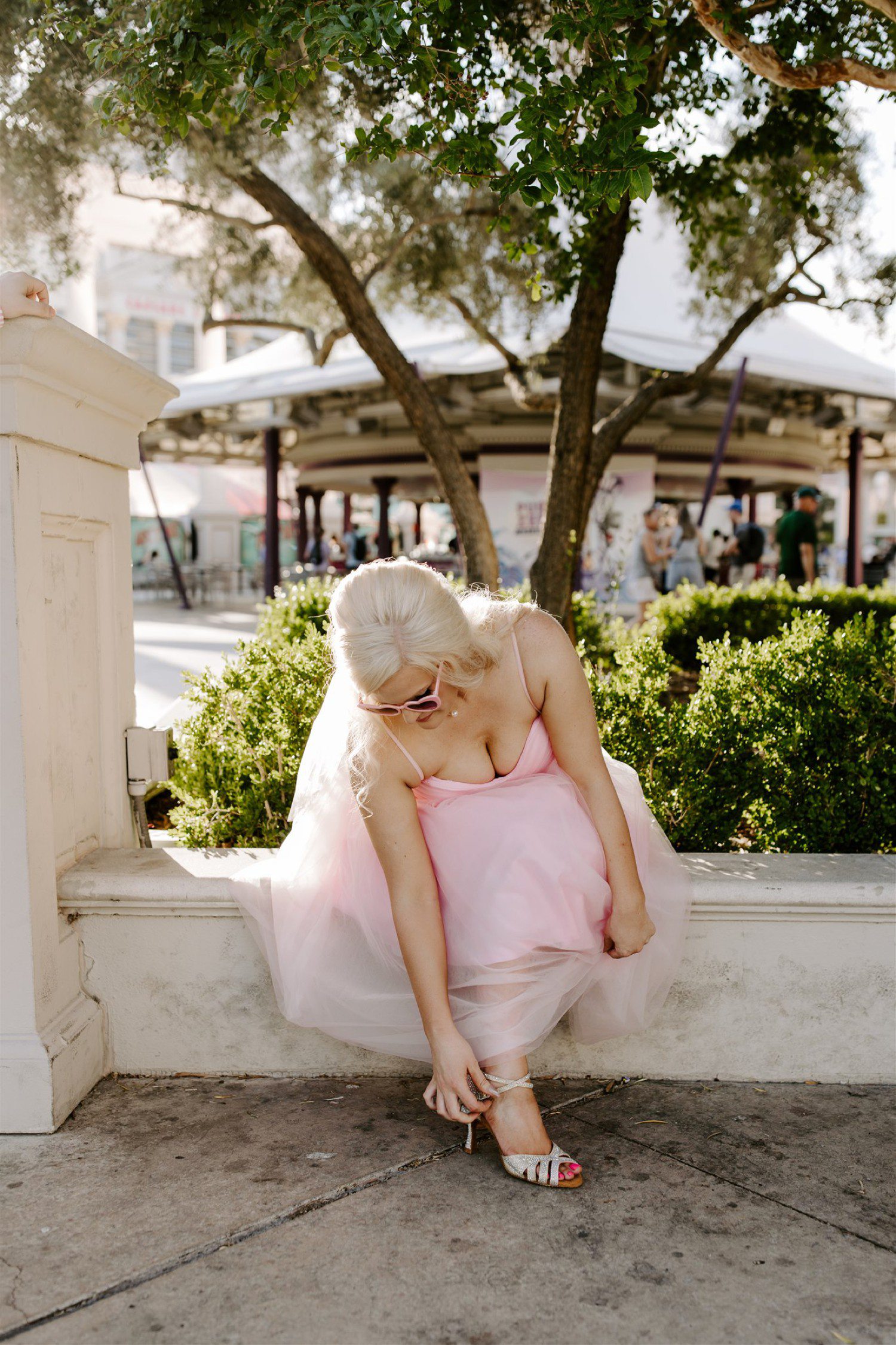 Bride wearing pink wedding dress with pink sunglasses.