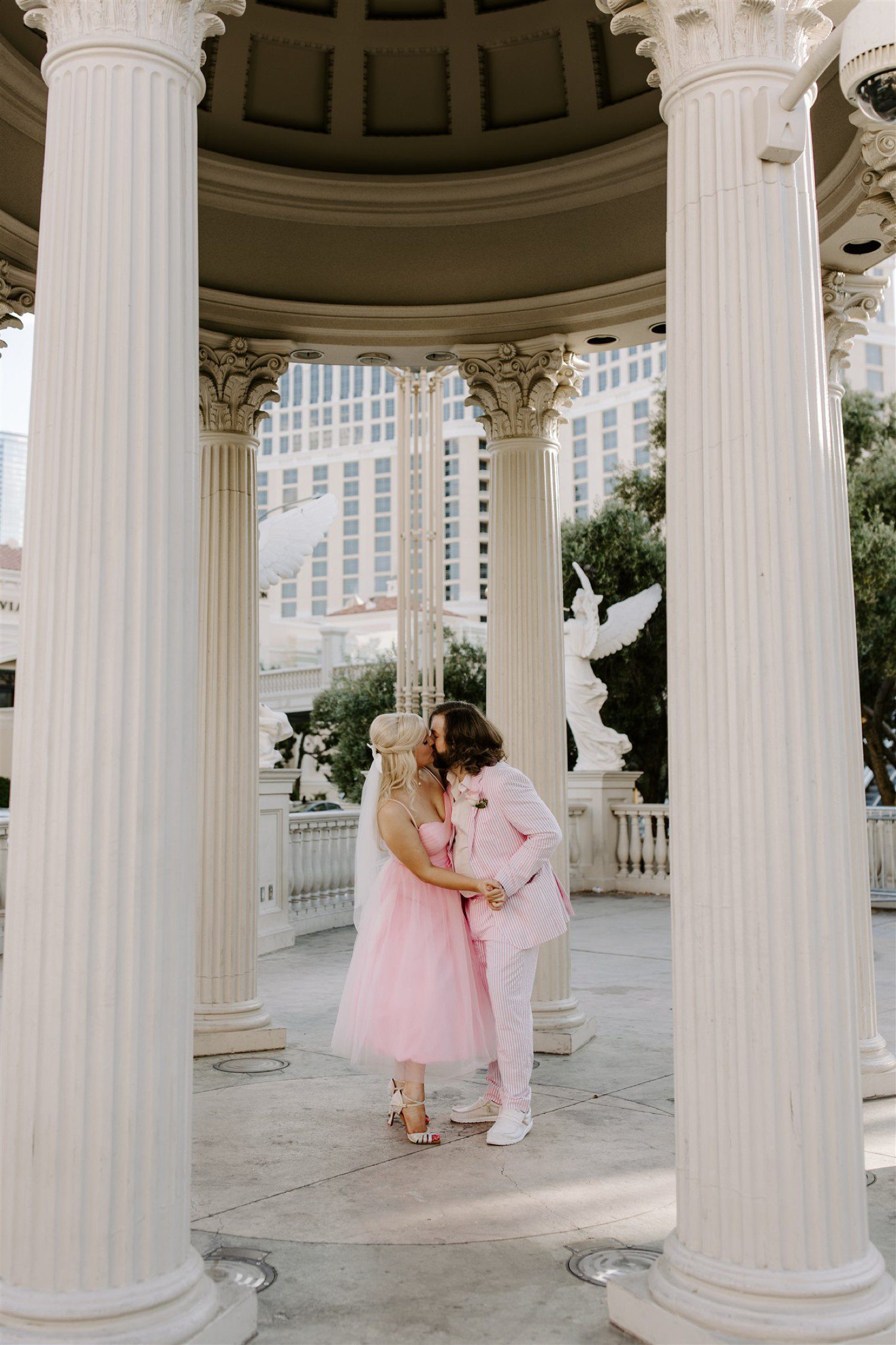 Couple wearing pink wedding dress and suit for Las Vegas wedding.