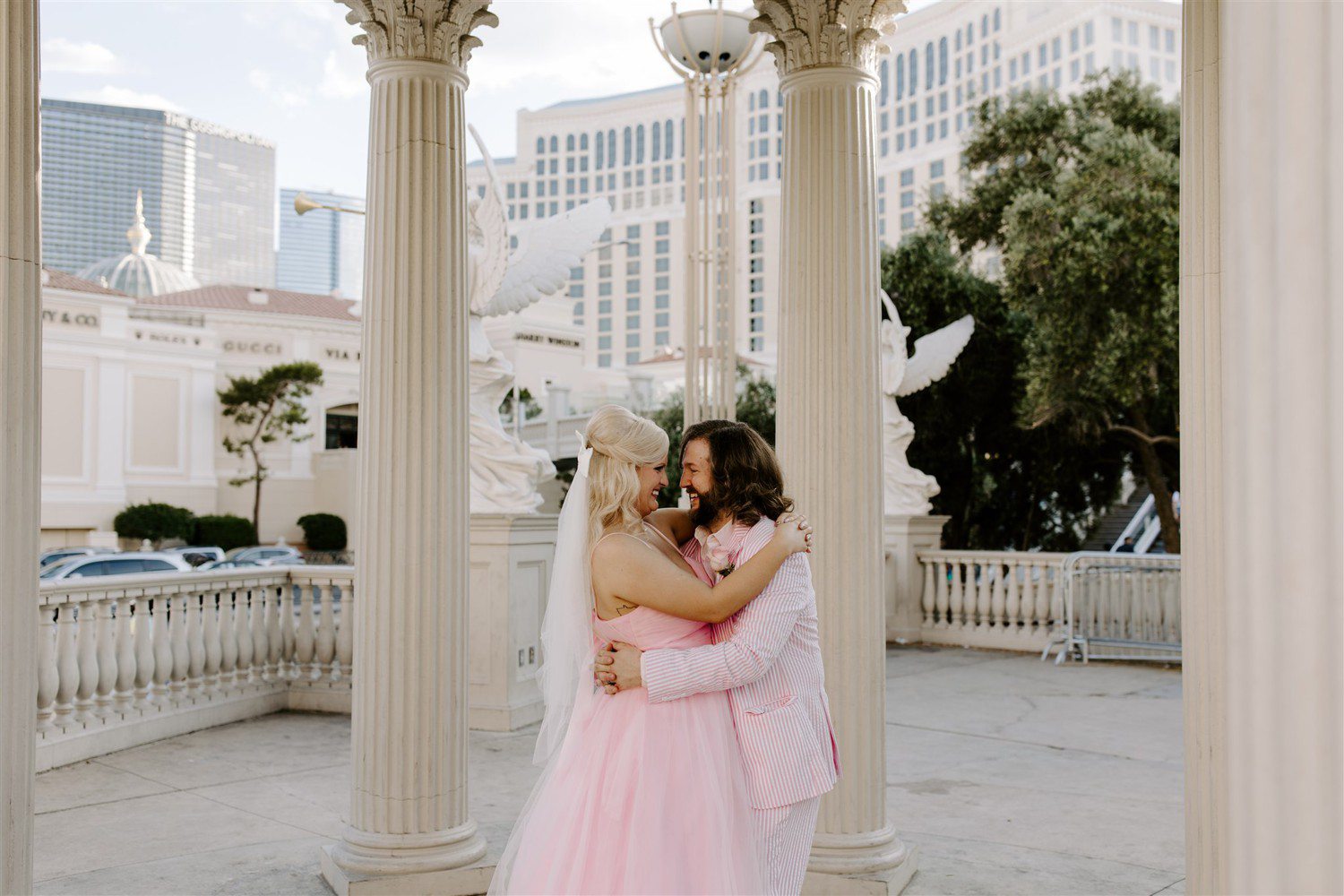 Bride wearing a pink wedding dress and groom in pink suit for Las Vegas wedding.