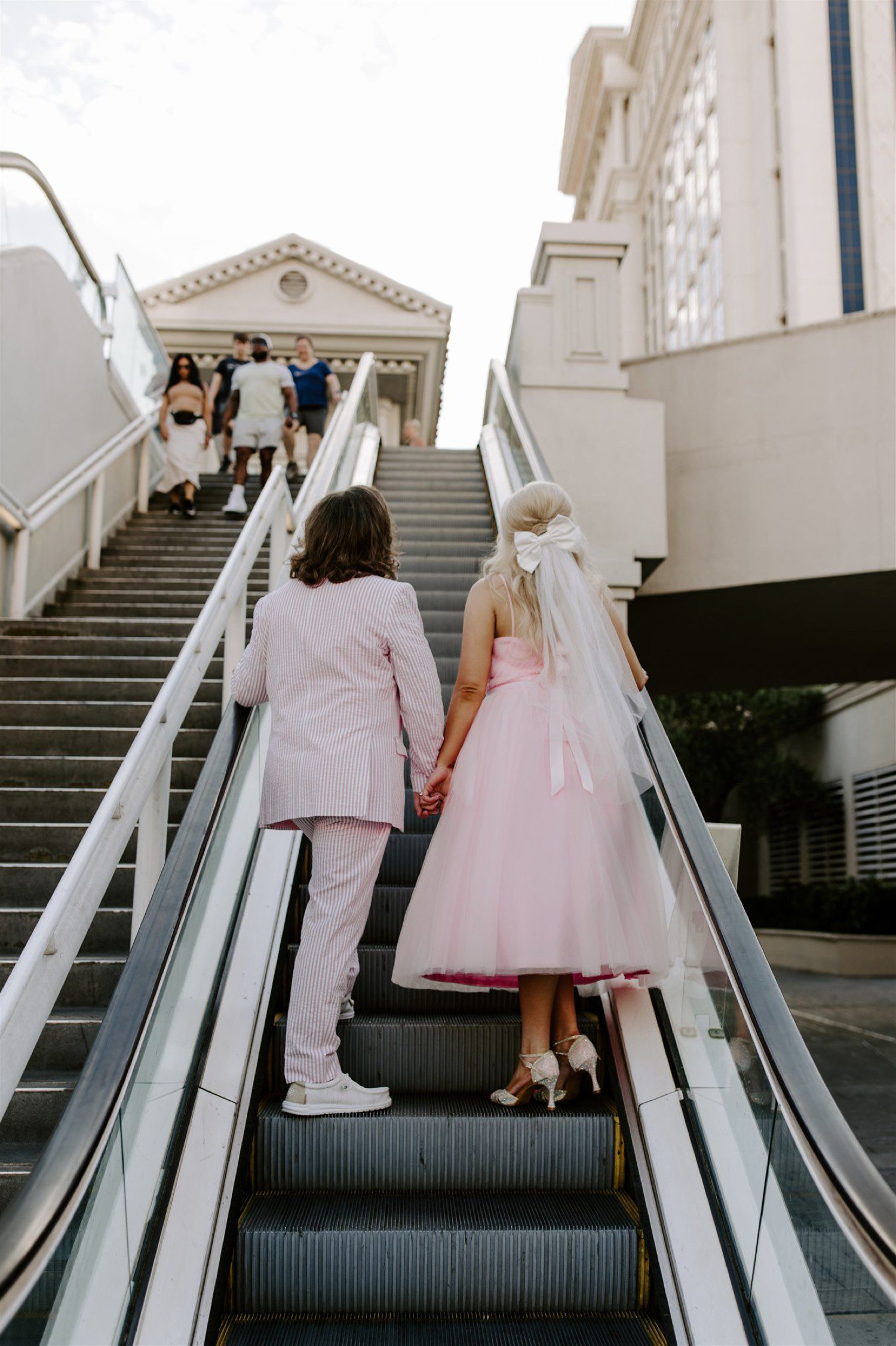 Bride and groom riding escalator together in Las Vegas.