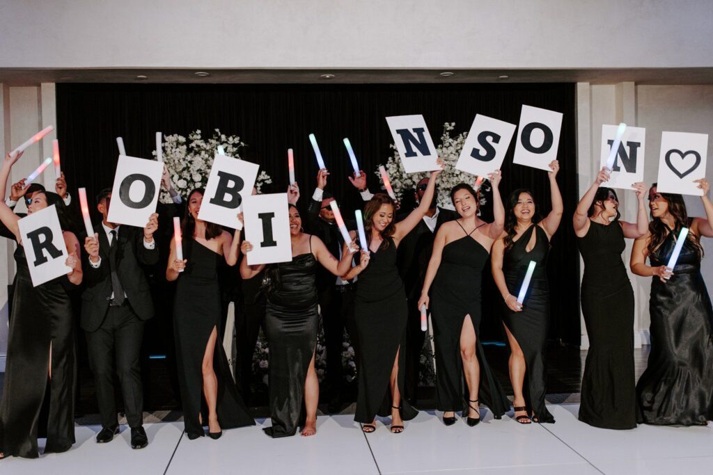 Wedding party with signs at reception.