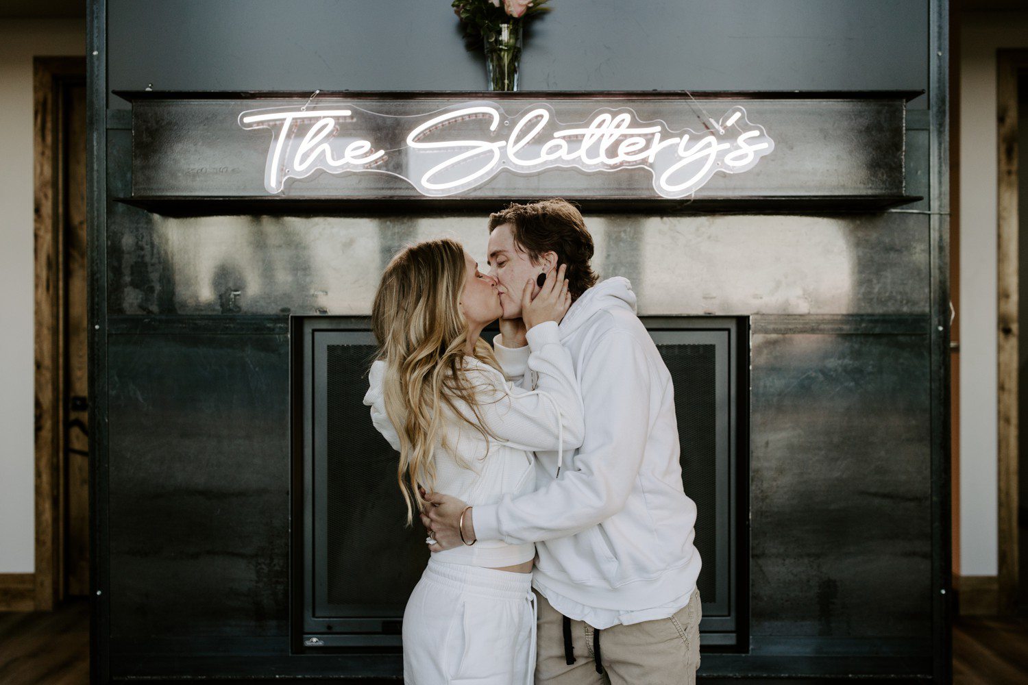 Wedding photos in front of neon sign with couples last name.