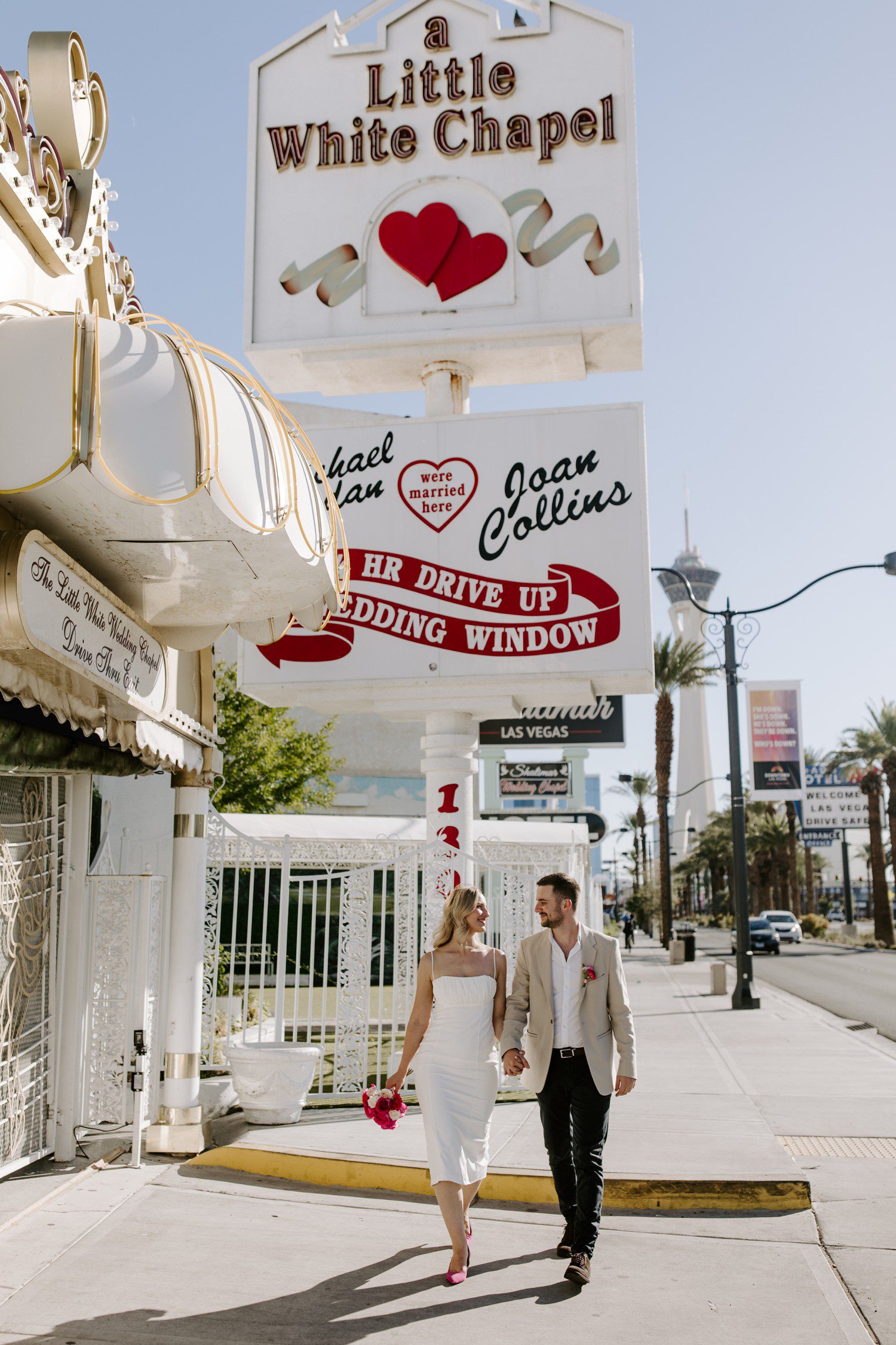 Wedding photos outside of A Little White Chapel sign.