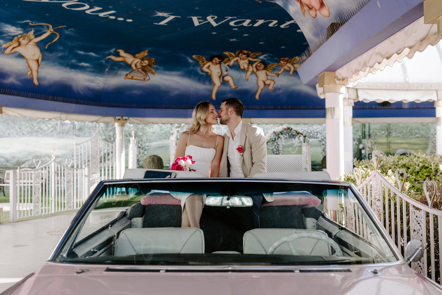 Elopement photos in the pink Cadillac at Little White Chapel.