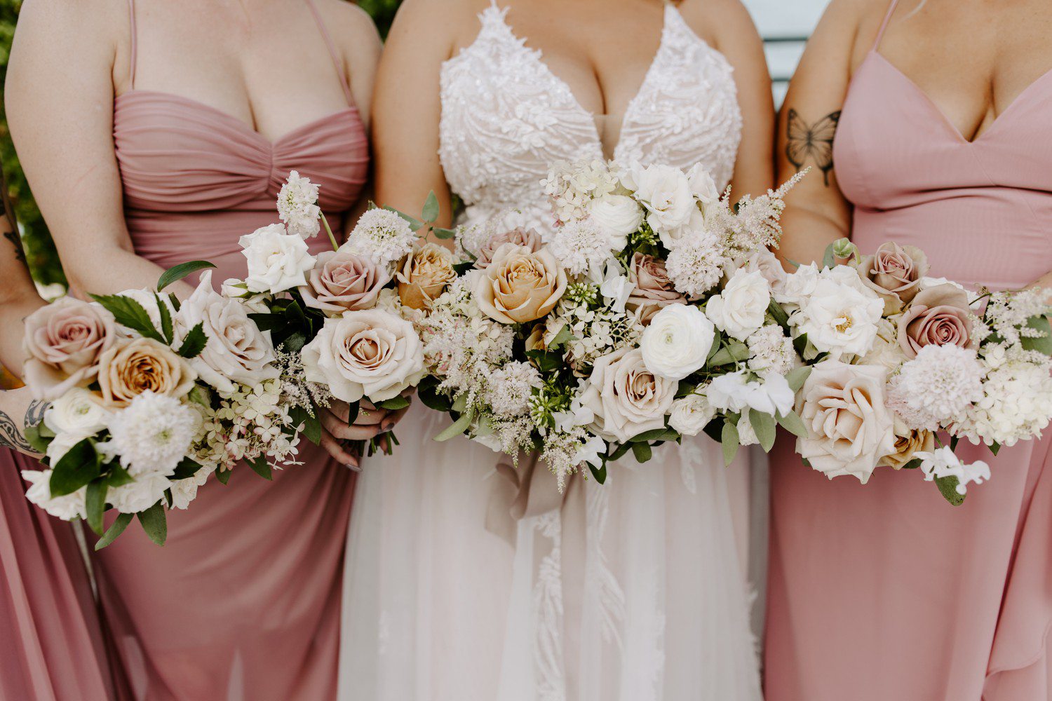 Bride and bridesmaid bouquets with white and light pink flowers.