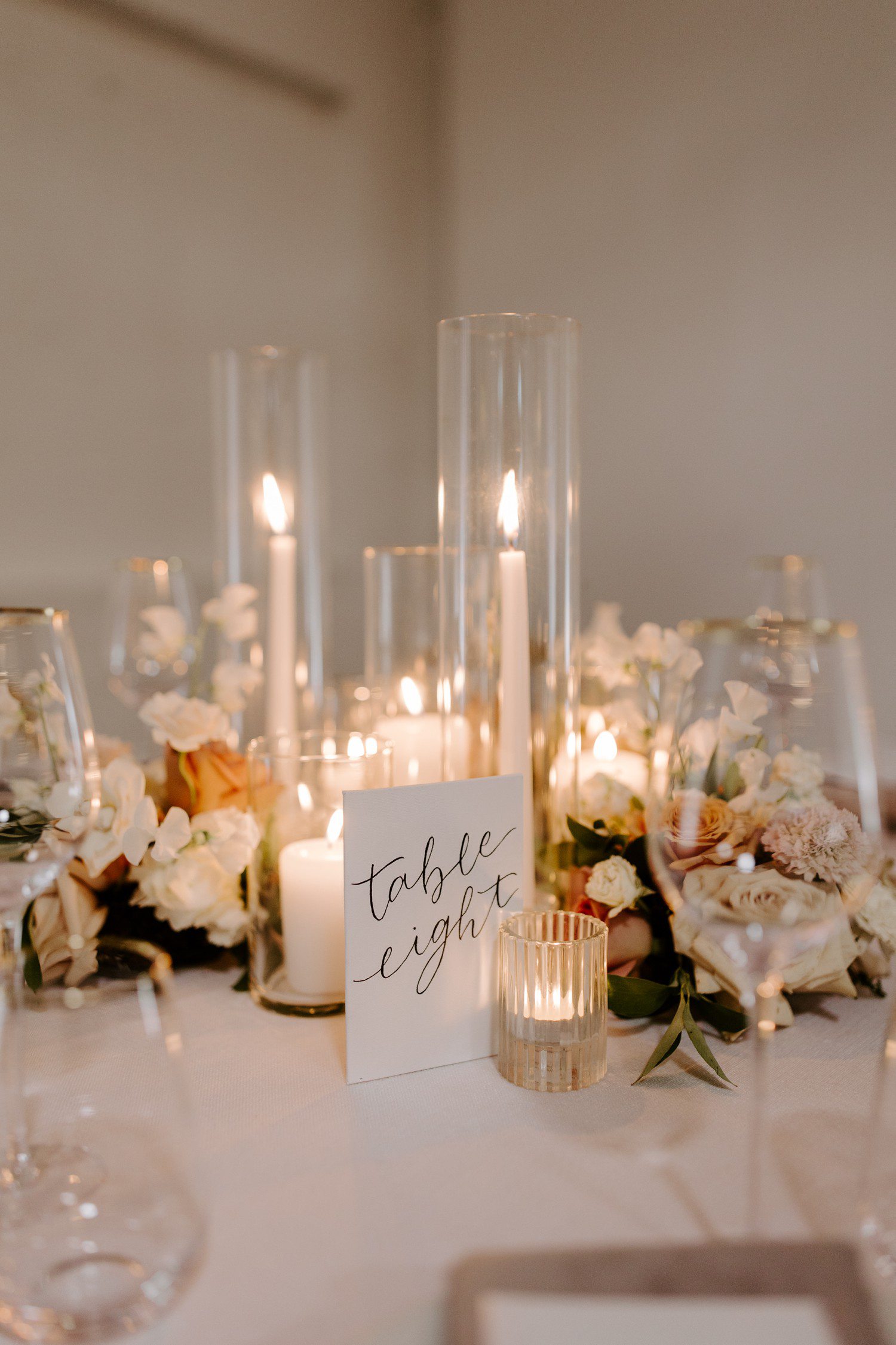 Wedding table decor with long white taper candles.