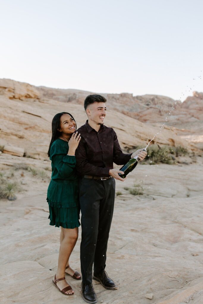 Popping champagne for engagement photos after proposal.