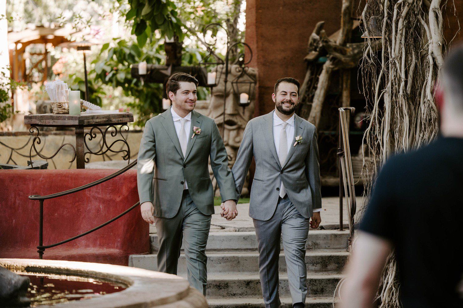 Two grooms walking down the aisle together.