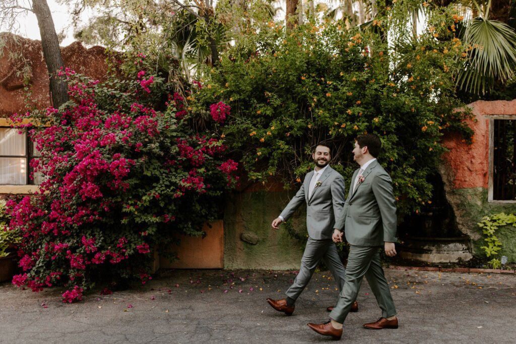 Two grooms walking together for wedding photos in Phoenix.