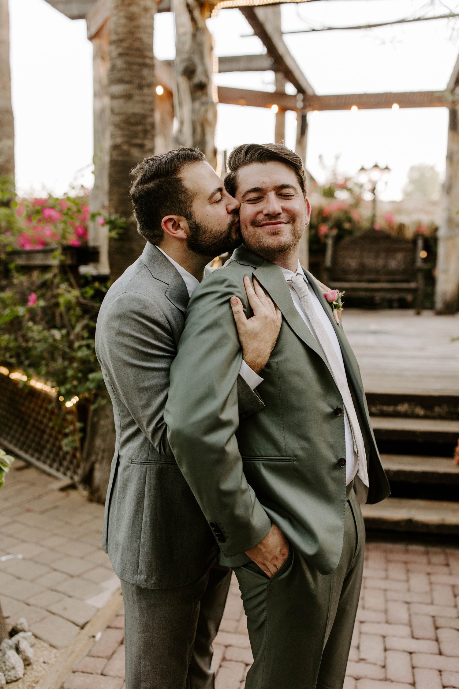 Wedding photos of groom kissing partner on the cheek.