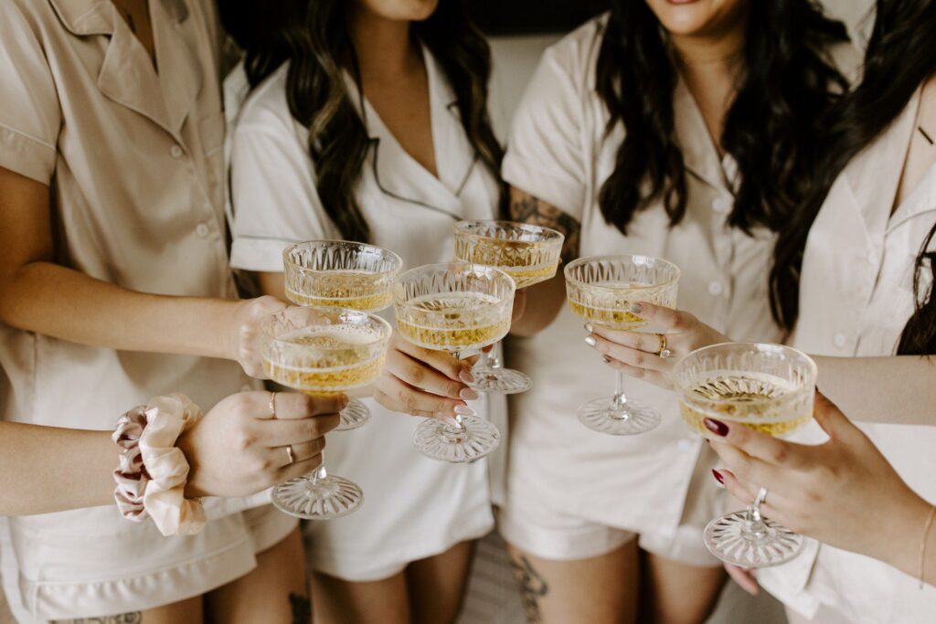 Bride and bridesmaids toasting champagne glasses.