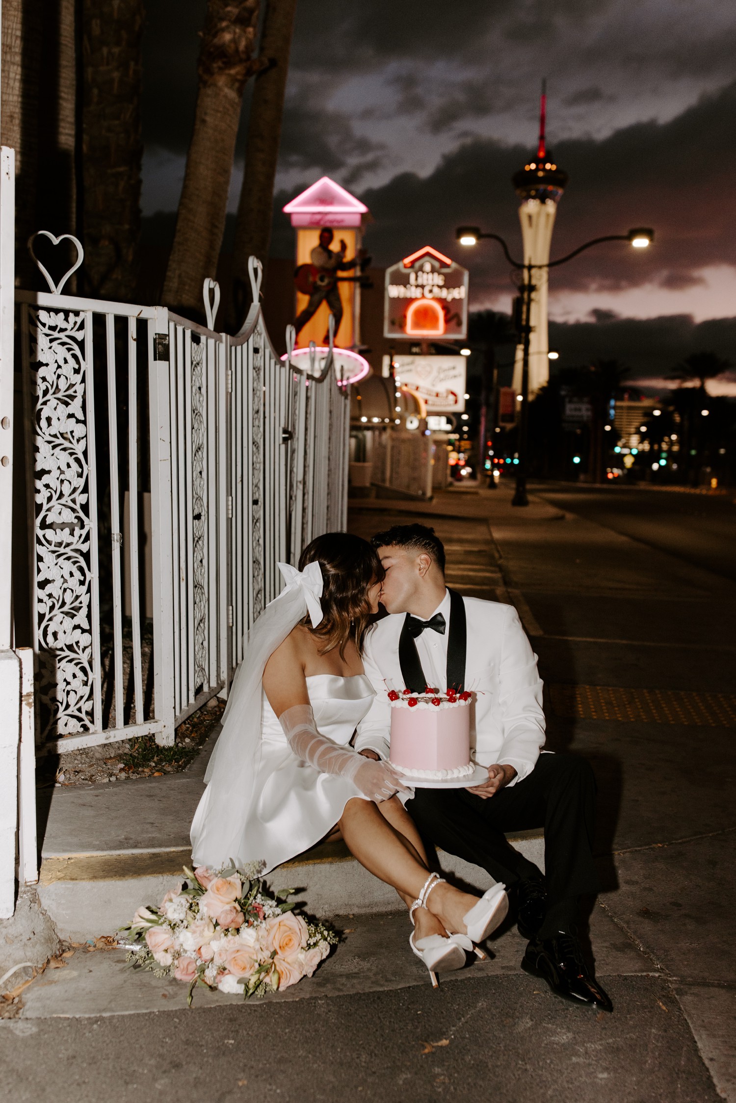 Couple with mini elopement cake outside of A Little White Chapel in Las Vegas. 