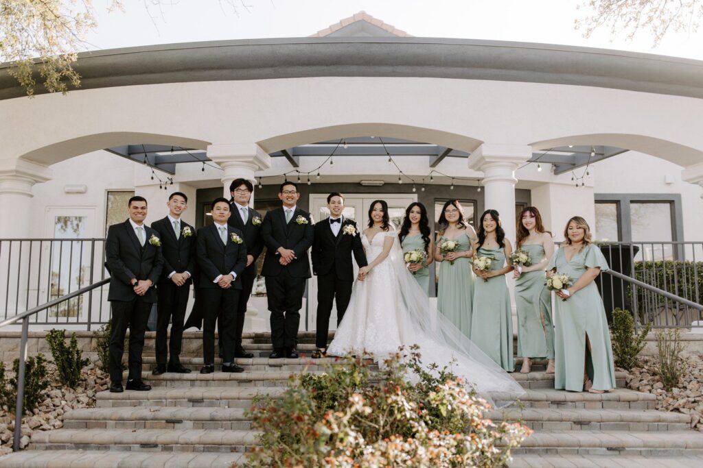 Spring wedding at Adorn Events in Las Vegas with wedding party in light green bridesmaids dresses and groomsmen in black suits. 