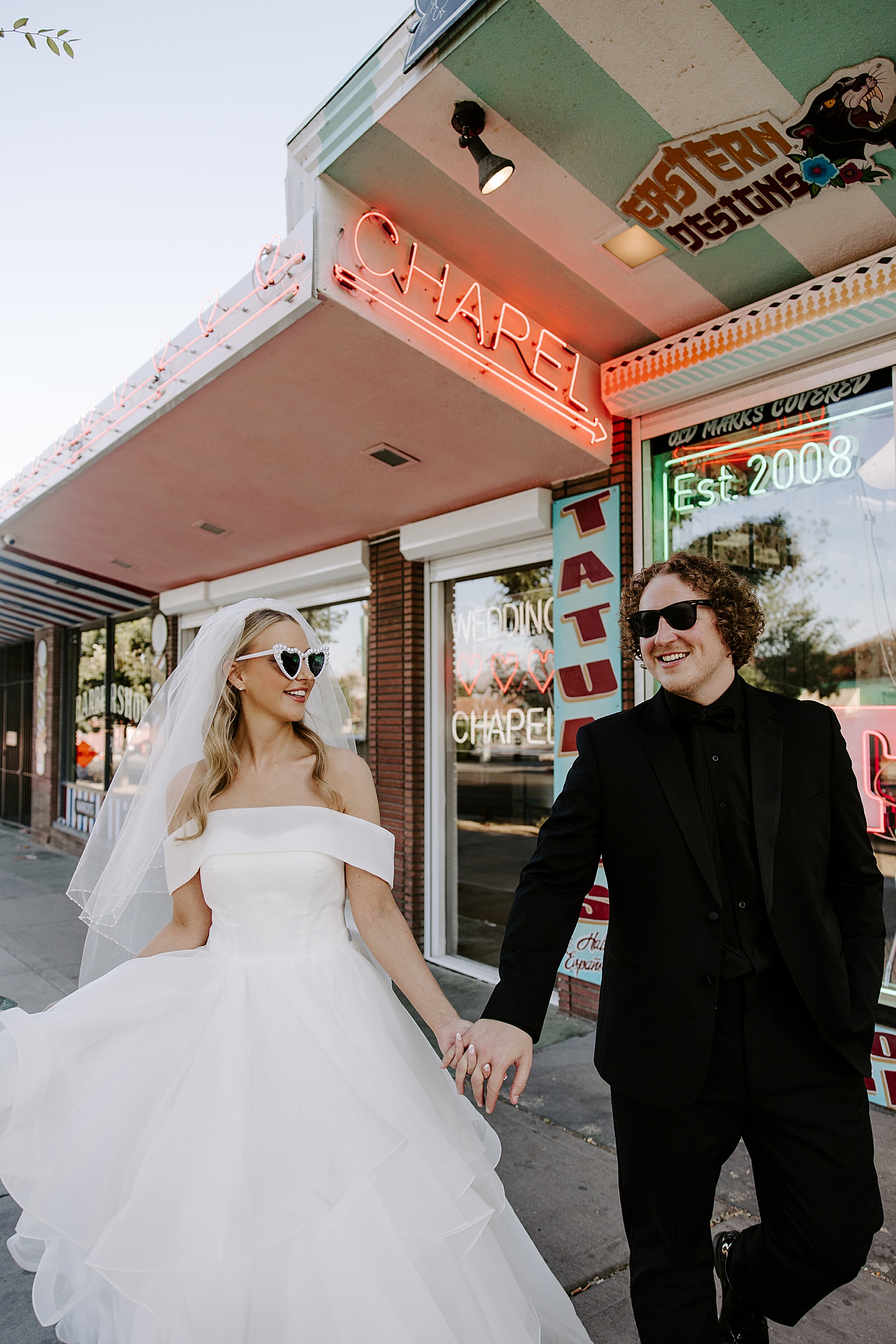 man and woman hold hands walking down the street after getting married by Katelyn Faye Photography