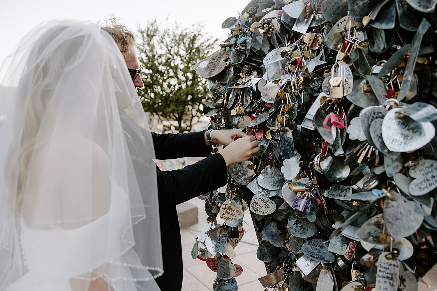 newlyweds put lock on fence after getting married by Katelyn Faye Photography