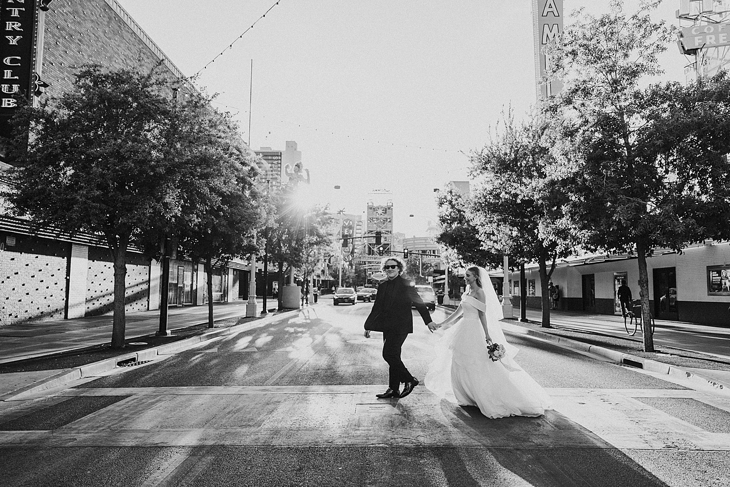 husband leads wife across crosswalk after getting married at Sure Thing Chapel