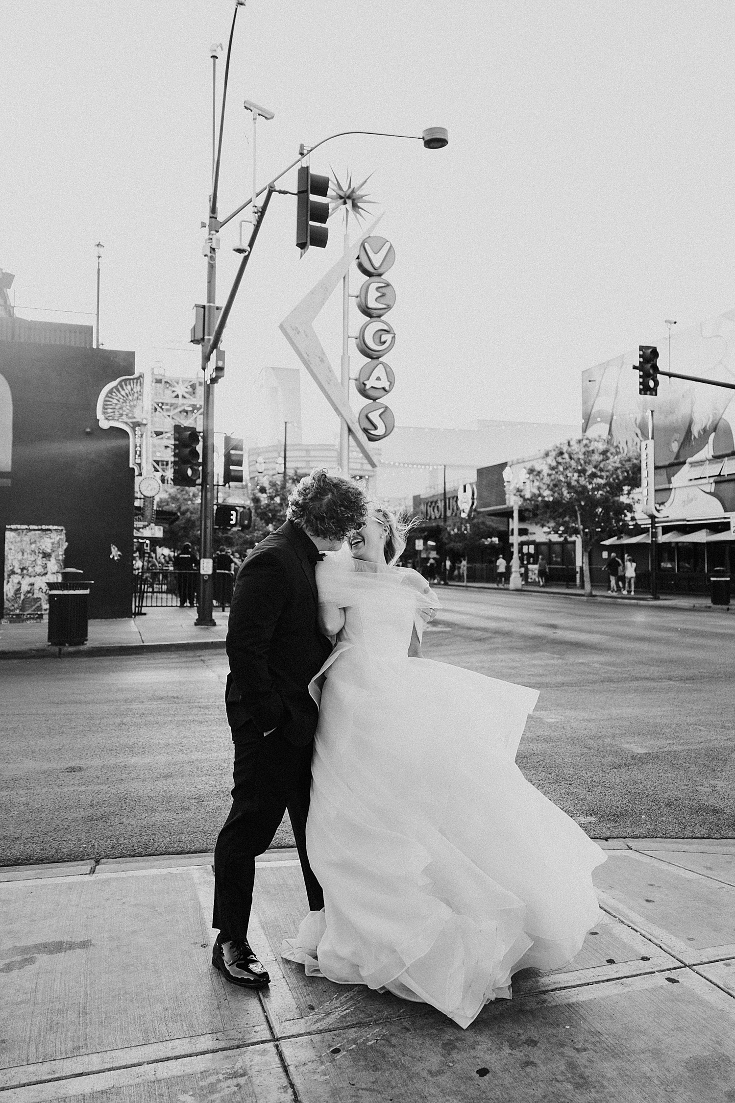 man leans in to kiss bride in the wind by Las Vegas elopement photographer