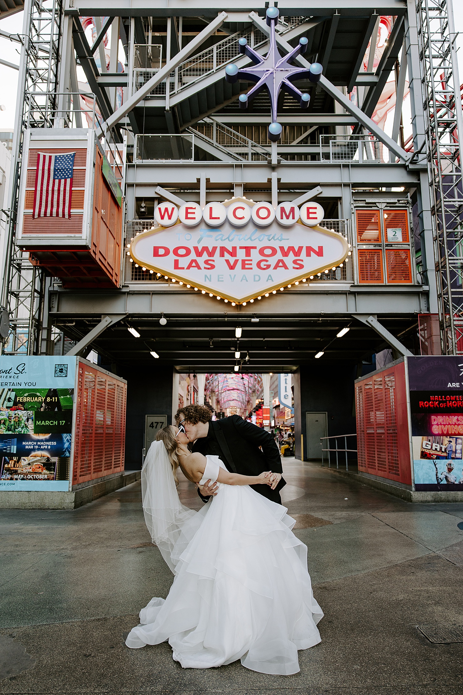 mand dips new wife for kiss in front of welcome to Vegas sign by Katelyn Faye Photography