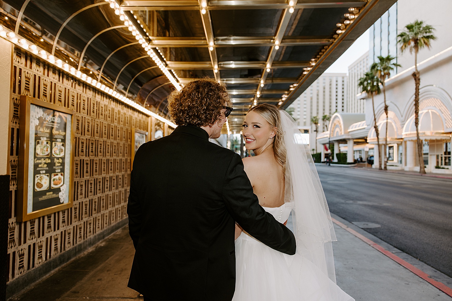 bride looks over her shoulder walking down the Strip by Katelyn Faye Photography