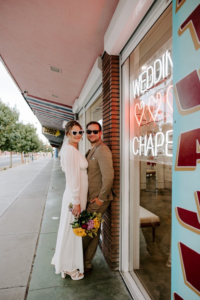 woman leans against man in front of Sure Thing Chapel by Las Vegas wedding photographer