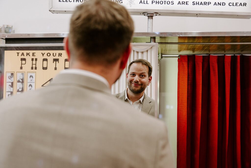 groom makes face at himself in the mirror by Katelyn Faye Photography