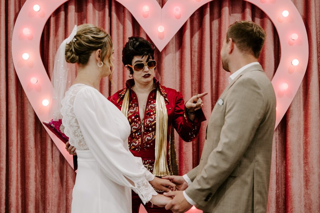 Elvis impersonator points at groom by Las Vegas wedding photographer