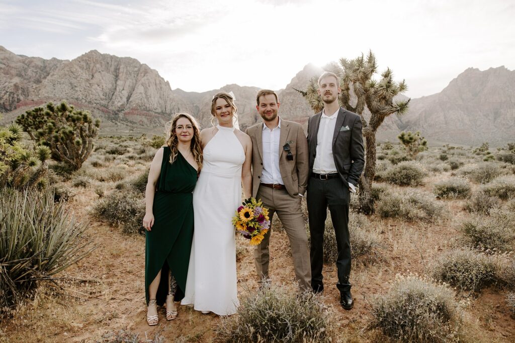 newlyweds and friends stand together in desert by Katelyn Faye Photography