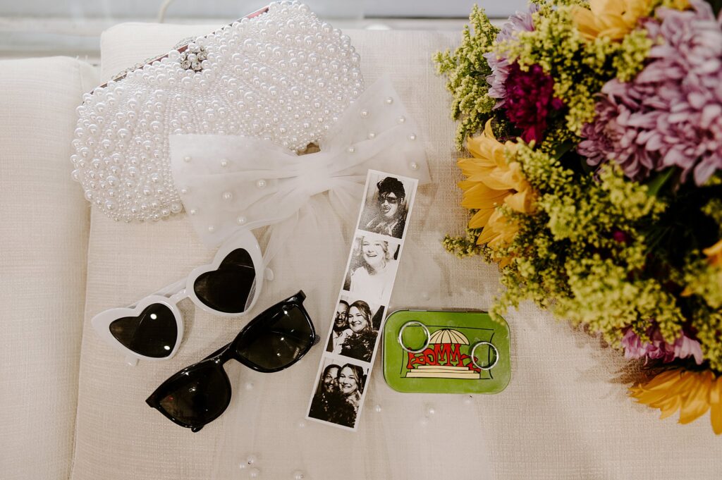 wedding flat lay includes veil, sunglasses, rings, and photo strip after Spring Mountains elopement