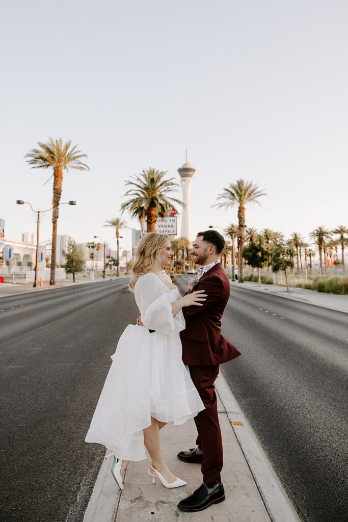 couple stands together on median in front of the strip by Katelyn Faye photography