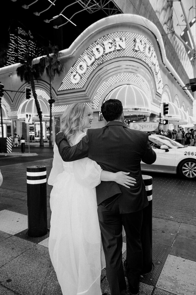 couple walks around Fremont street after wedding by Katelyn Faye photography