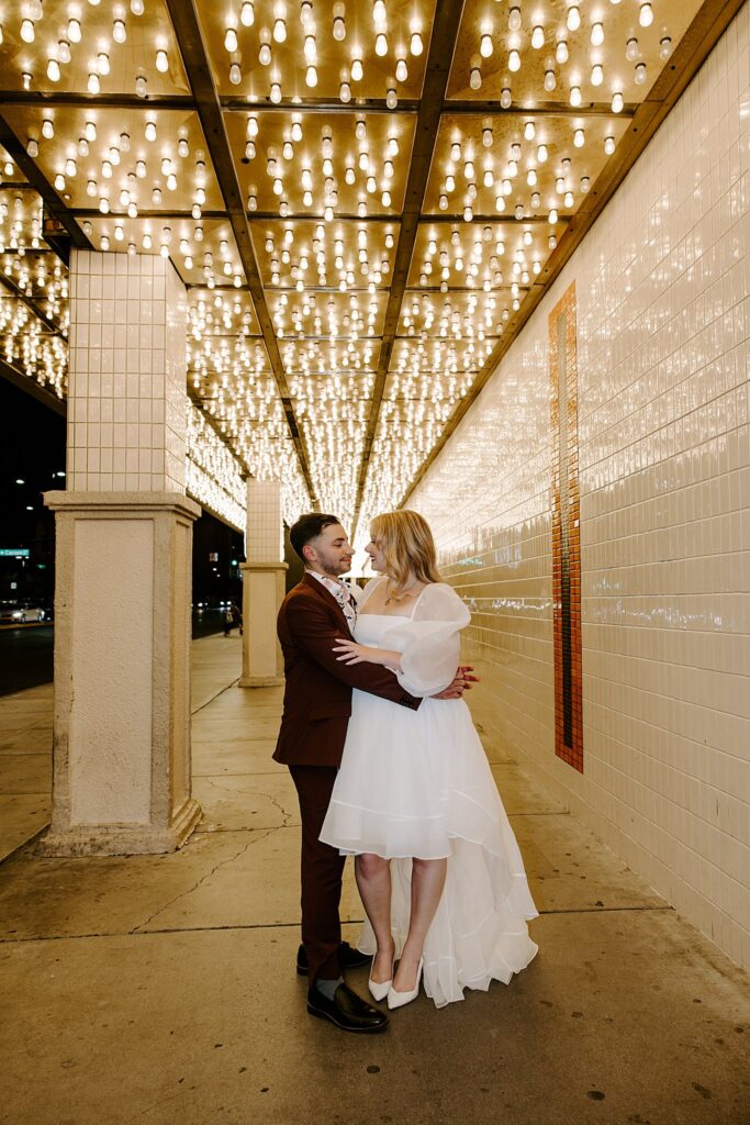 groom holds his wife around the waist by Las Vegas elopement photographer