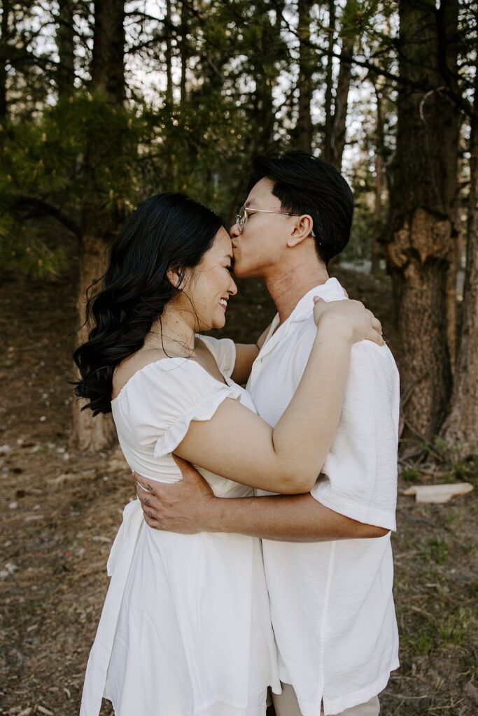 man kisses woman on forehead during Mt. Charleston engagement session 