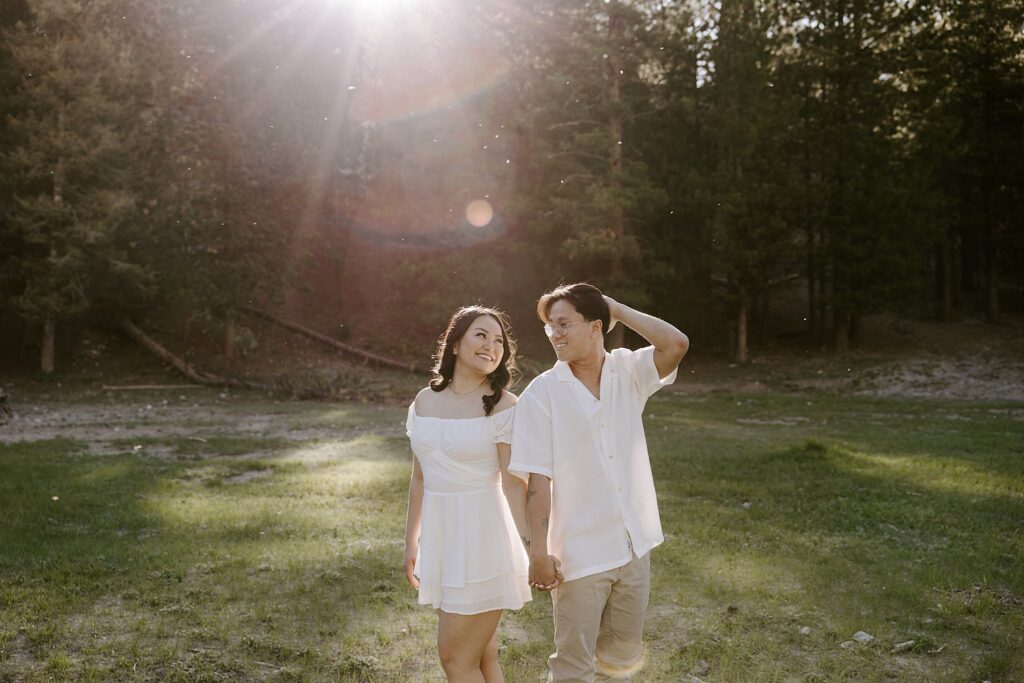 man and woman look over shoulders at each other by Las Vegas wedding photographer