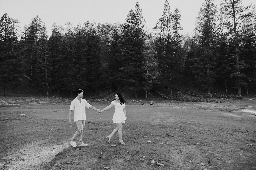 woman walks holding hands with fiance as she looks back at him during Mt. Charleston engagement session 