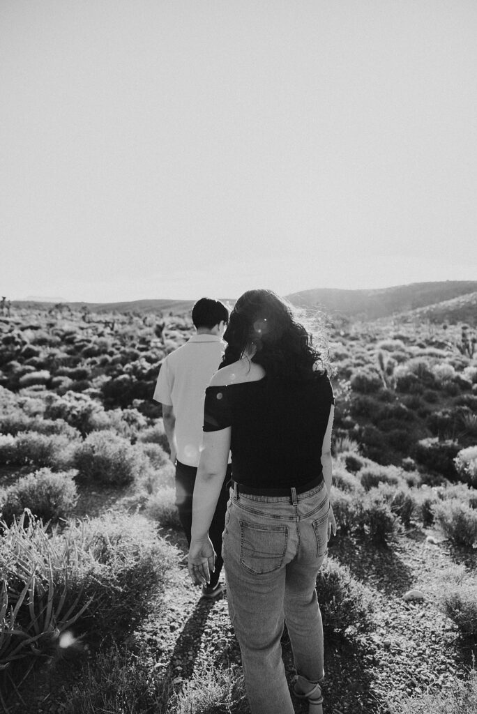 couple walks through brush together during Mt. Charleston engagement session 