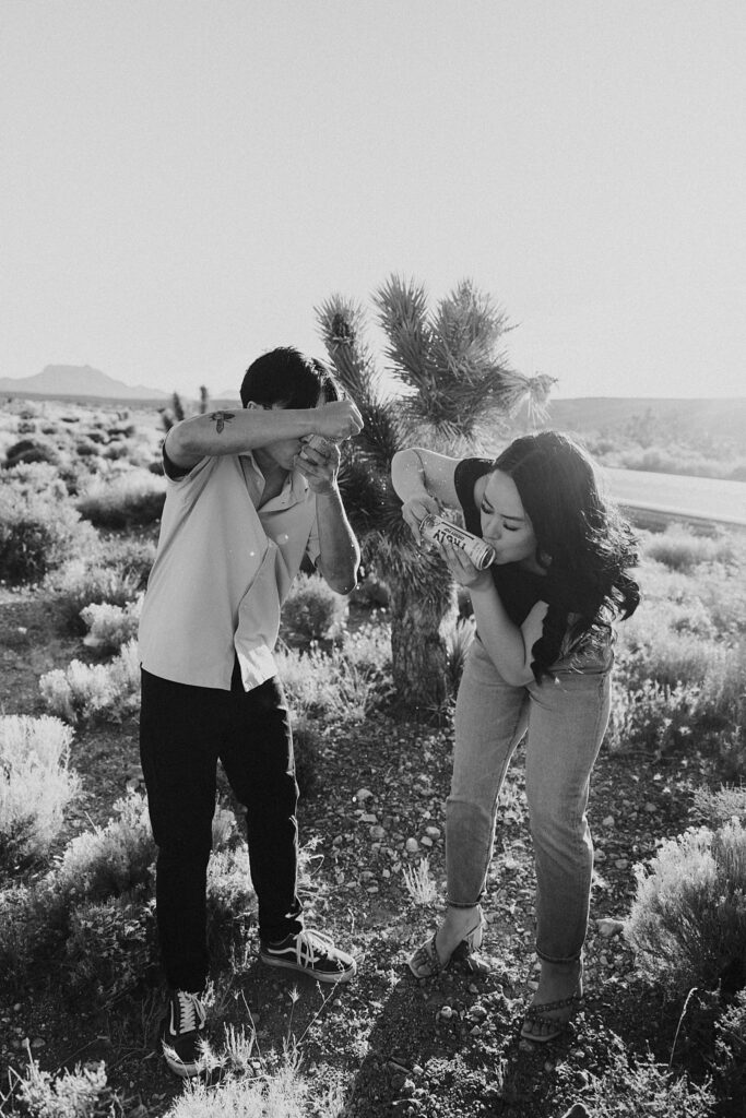 couple shotguns drinks during engagement session by Katelyn Faye Photography