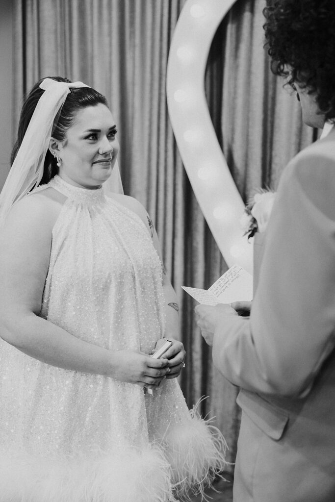 bride smiles at groom during ceremony by Katelyn Faye Photography