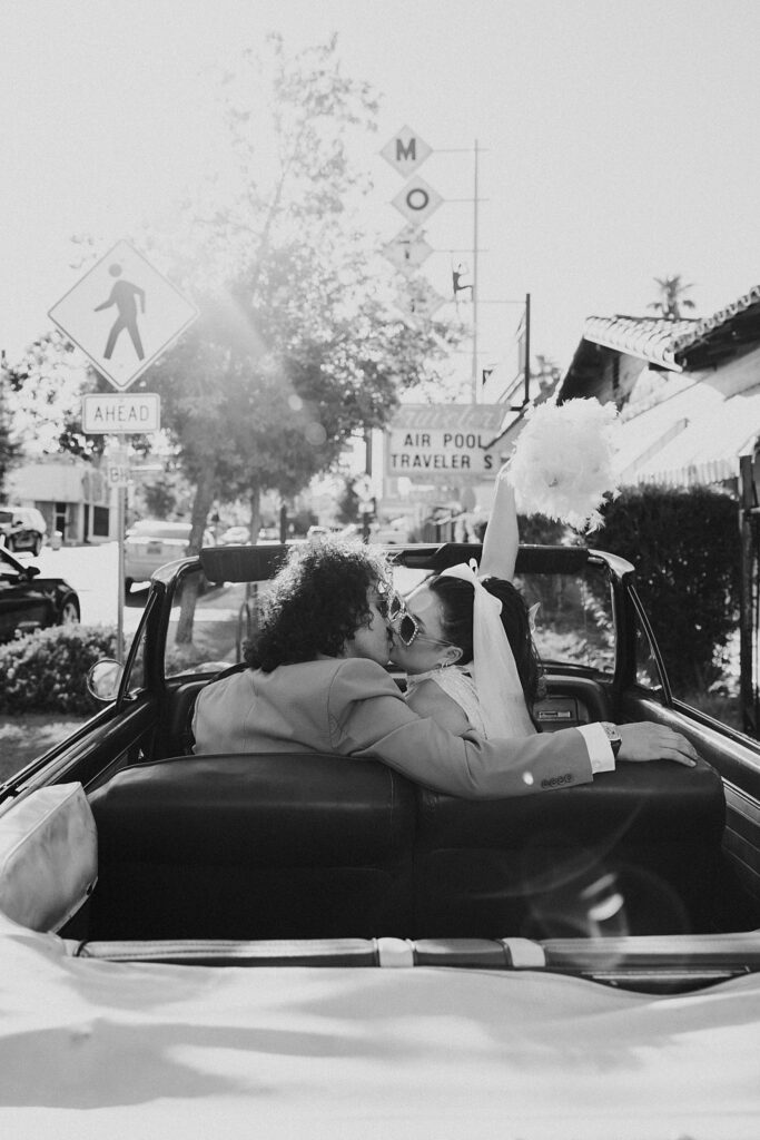 bride holds up bouquet while she kisses groom by Vegas wedding photographer