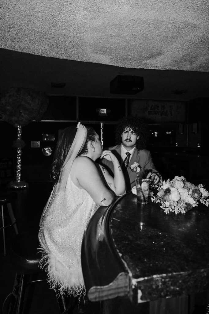 couple shares drinks at bar by Vegas wedding photographer