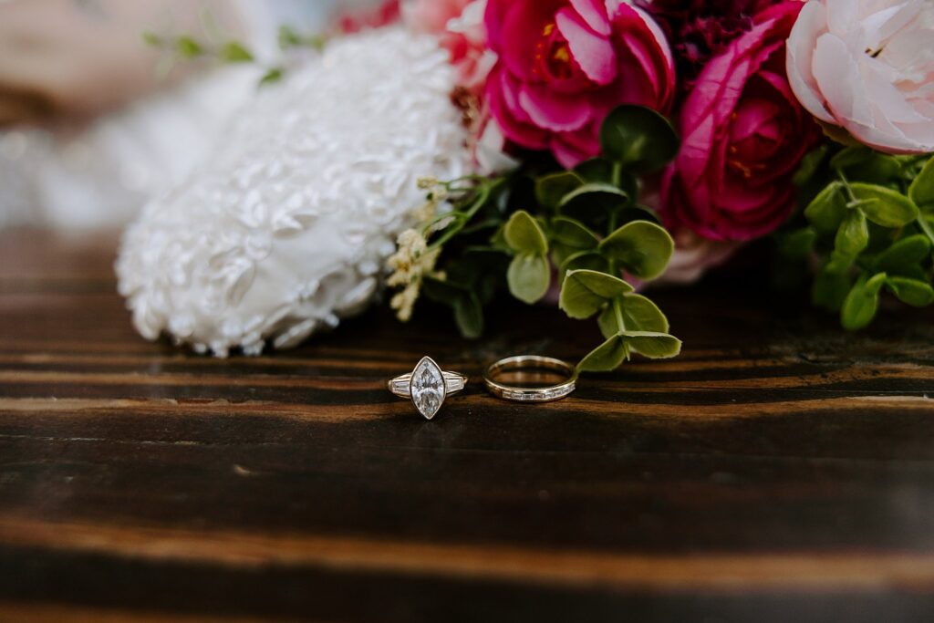 wedding rings sit on table by bouquet by Katelyn Faye Photography